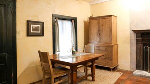 A dining area with a wooden table and chairs, a cabinet, and a fireplace.