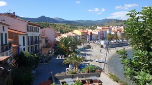 Un pueblo costero con edificios, una playa y montañas al fondo.