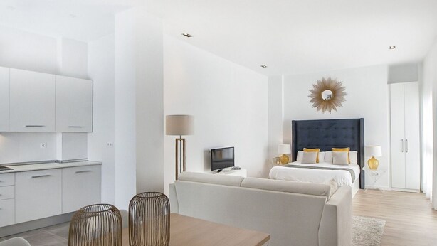 A modern hotel room with a sofa, a dining table, and a TV. - iloftmalaga Císter Estudio (Málaga)