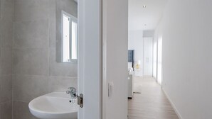 A modern bathroom with a white sink, wooden shelves, and a mirror. - iloftmalaga Císter Estudio (Málaga)