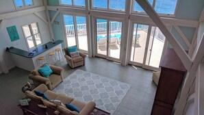 Amplia sala de estar con un ventanal que da a un balcón con piscina. Hay dos sofás y una mesa de centro.