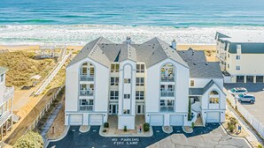 A beachfront hotel with a symmetrical facade, multiple balconies, and a 'No Parking Fire Lane' sign.