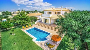 A two-story house with a swimming pool, surrounded by lush greenery and a clear sky. - Villa Altair - Four Bedroom Villa, Sleeps 8 (Casa Altair Joinal)