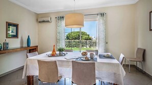 A dining area with a table set for two, a hanging lamp, and a view of greenery outside. - Villa Altair - Four Bedroom Villa, Sleeps 8 (Casa Altair Joinal)