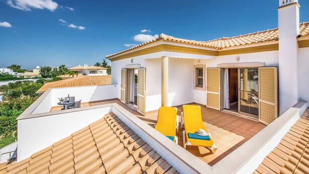 A rooftop terrace with two yellow lounge chairs, a table, and a view of the surrounding area. - Villa Altair - Four Bedroom Villa, Sleeps 8 (Casa Altair Joinal)