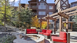 A patio area with outdoor seating, a fire pit, and a stone fire ring.