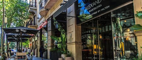 A hotel named 'ALEXANDRA BARCELONA' with a doubletree by Hilton, featuring outdoor seating and potted plants.