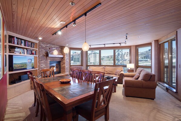 A spacious living area with a fireplace, a dining table, and comfortable seating. - CX133 | Ski In/Out | Slopeside Convenience | Winter Shuttle | Amazing Views (Steamboat Springs)