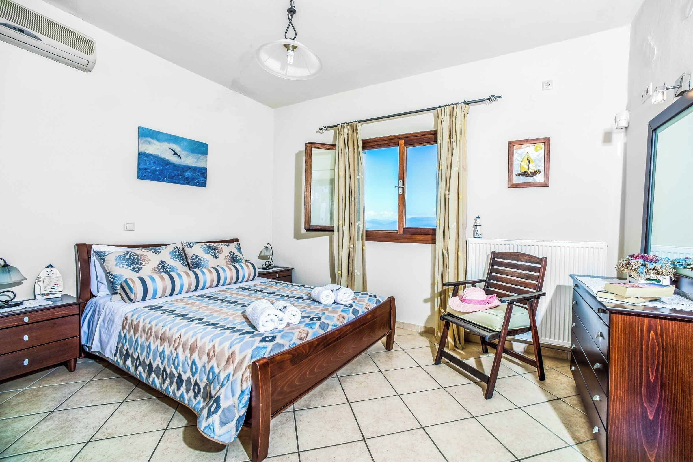 Une chambre à coucher avec un lit, une chaise, un bureau et une fenêtre avec des rideaux.
