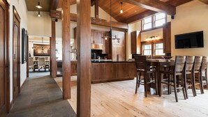 Un'ampia cucina con mobili in legno, un'isola grande e un'area pranzo con sedie.