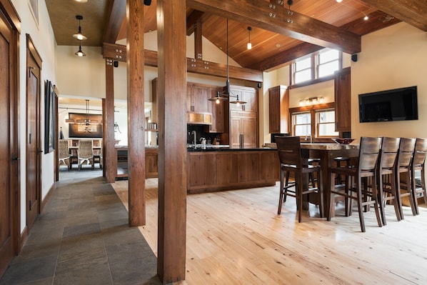A spacious kitchen with wooden cabinets, a large island, and a dining area with chairs.