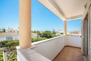 Un balcón con vistas a casas vecinas y vegetación.