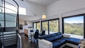 Ein modernes Interieur mit Essbereich, einer Couch und einer Küche.