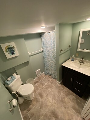 Une salle de bain équipée de toilettes, d’un lavabo et d’un rideau de douche.