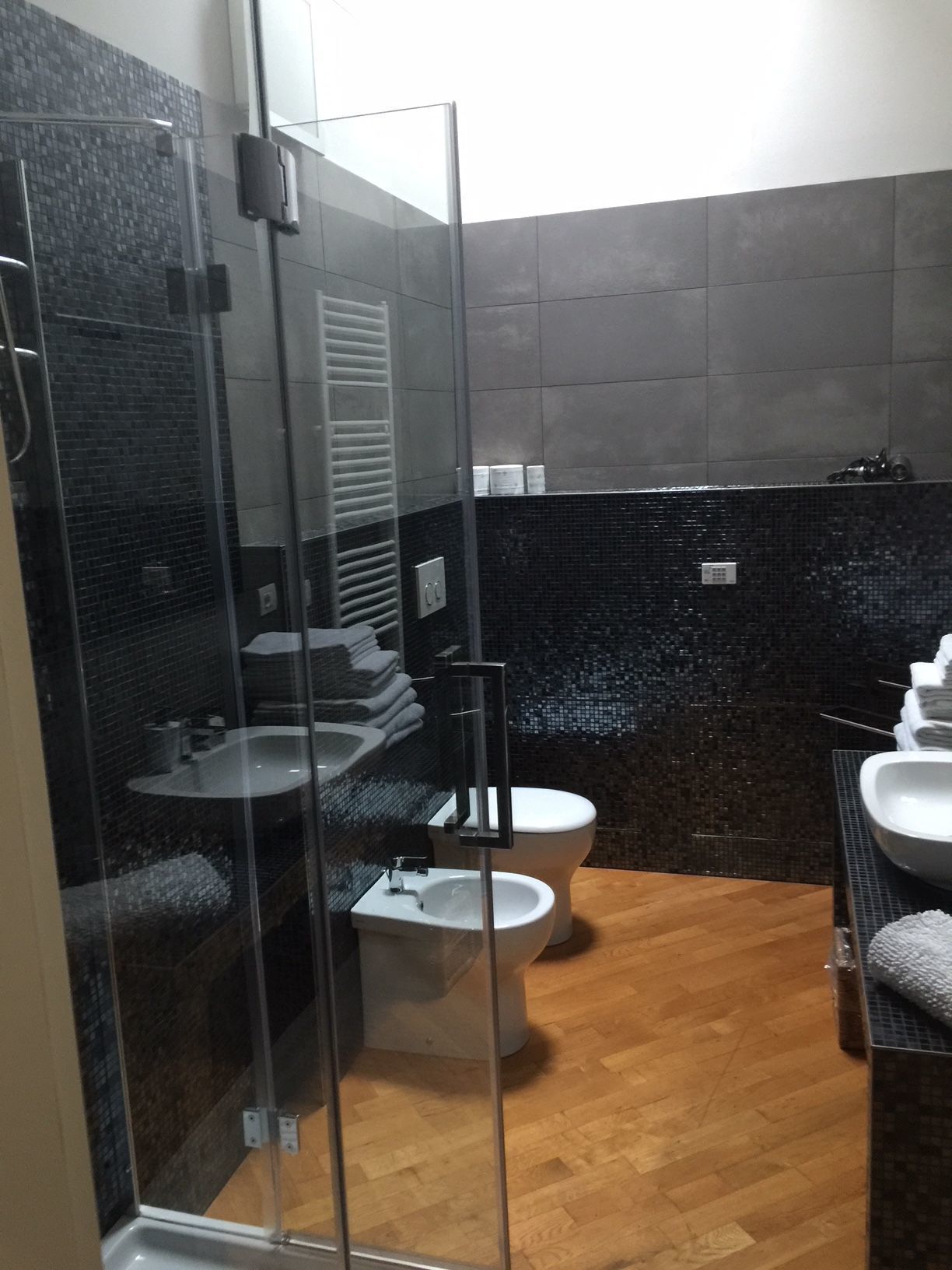 Un baño moderno con cabina de ducha de vidrio, inodoro y lavabo.