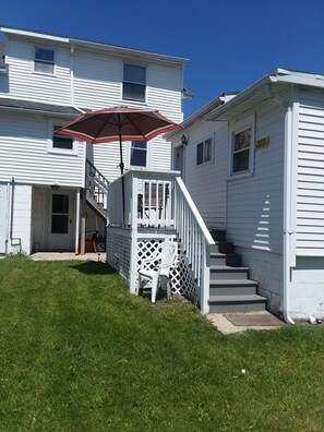 A two-story white house with a covered porch, a staircase, and a 'Posted Keep Out' sign. - Central AC, child safe fenced in yard, 3 minutes to the beach. NO CLEANING FEE
(Hampton)