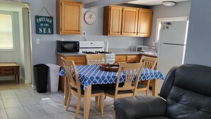 A compact living space with a dining area, kitchen, and seating area. - Central AC, child safe fenced in yard, 3 minutes to the beach.  NO CLEANING FEE
 (Hampton)