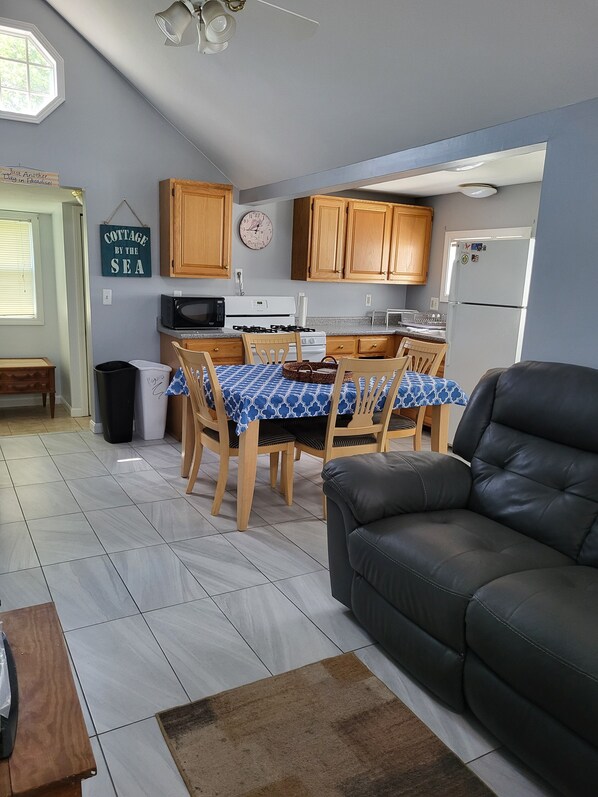 A compact living space with a dining area, kitchen, and seating area.