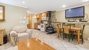 A cozy living room with a sofa, a wooden coffee table, and a TV mounted on the wall.