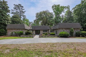 A two-story house with a front entrance, a driveway, and a well-maintained lawn. - 25 Red Maple: Sea Pines Home, Private Pool, Golf Views, Walk to Beach (Hilton Head Island)