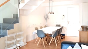 Un interior moderno con escalera, comedor y cocina.