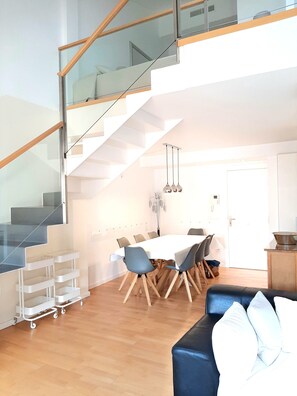 A modern interior with a staircase, dining area, and kitchen.