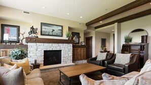 A cozy living room with a stone fireplace, leather sofas, and a coffee table. - Silver Star 1303 | Park City Condo with Pool Access, Hot Tub and Mountain Views (Park City)