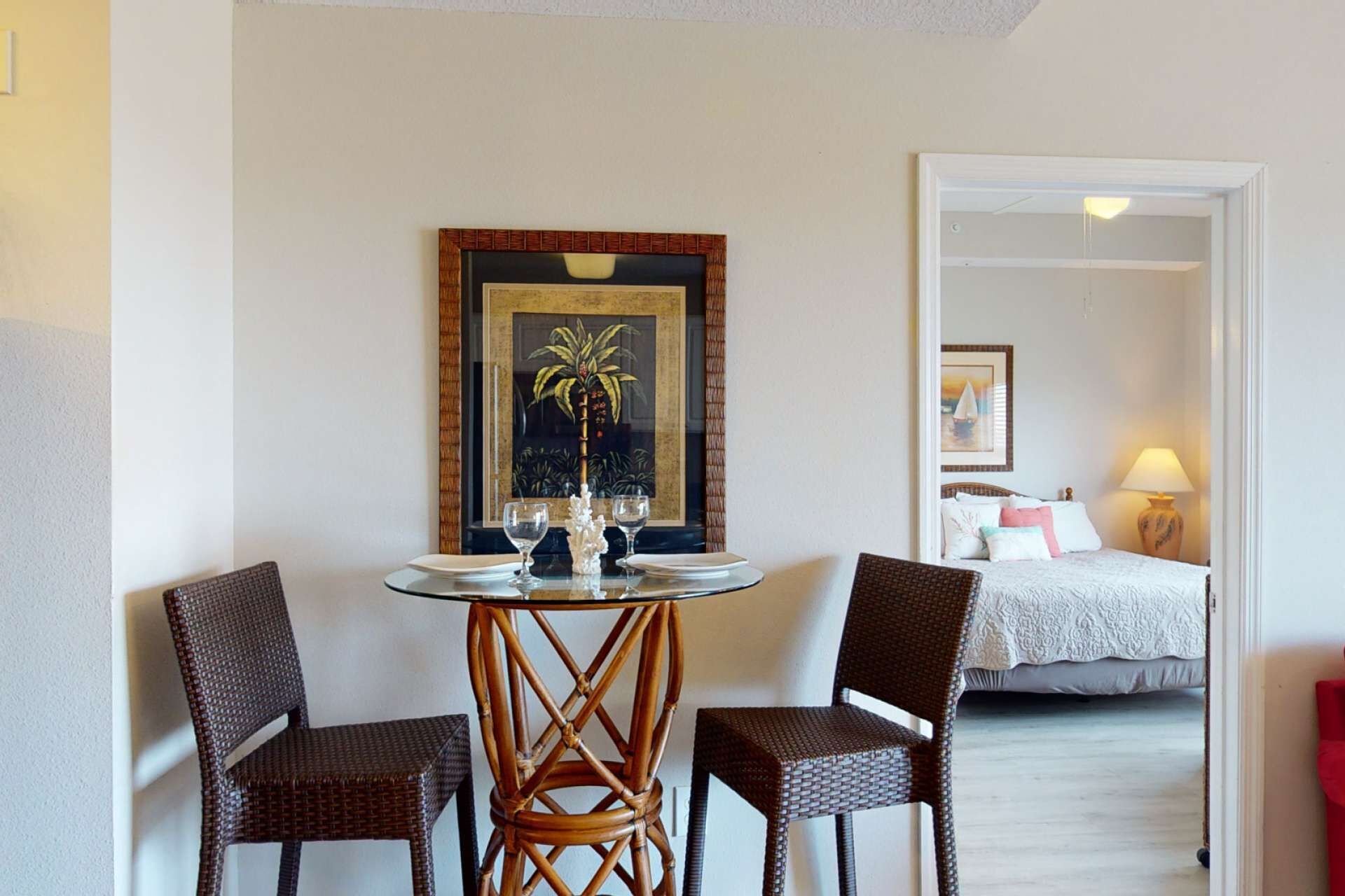 Una stanza con un letto, un tavolo con sedie e un quadro appeso al muro.