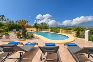 Un espace aménagé au bord de la piscine, avec des chaises longues et une piscine.