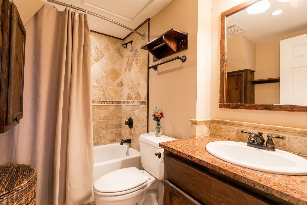 A bathroom with a bathtub, toilet, and sink.