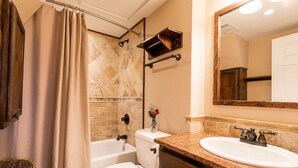 A bathroom with a bathtub, toilet, and sink.