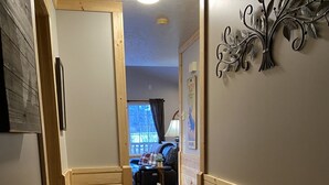 Un pasillo con paneles de madera y un tapete que conduce a una sala de estar.