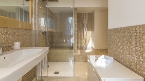 A modern bathroom with a glass-enclosed shower, a white sink, and a mirror. - Ca' Rossini 1 Apartment (Venice)