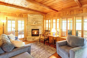 Un salón acogedor con chimenea, paredes de madera y asientos cómodos.