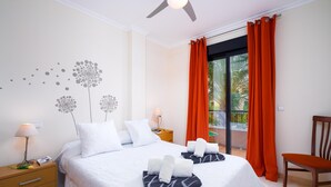 Une chambre d’hôtel avec un lit, une table de chevet, une chaise et une fenêtre avec des rideaux.