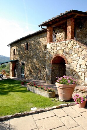 Traditional stone building with a charming entrance and lush surroundings.