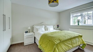 A bedroom with a bed, nightstand, and window. - 1 Bed in Northam, Bideford (oc-cedars) (Northam)