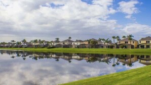 Zona residencial con casas y un lago tranquilo que refleja los edificios.
