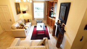 Una sala de estar con un sofá, una mesa de centro, un televisor y una chimenea.