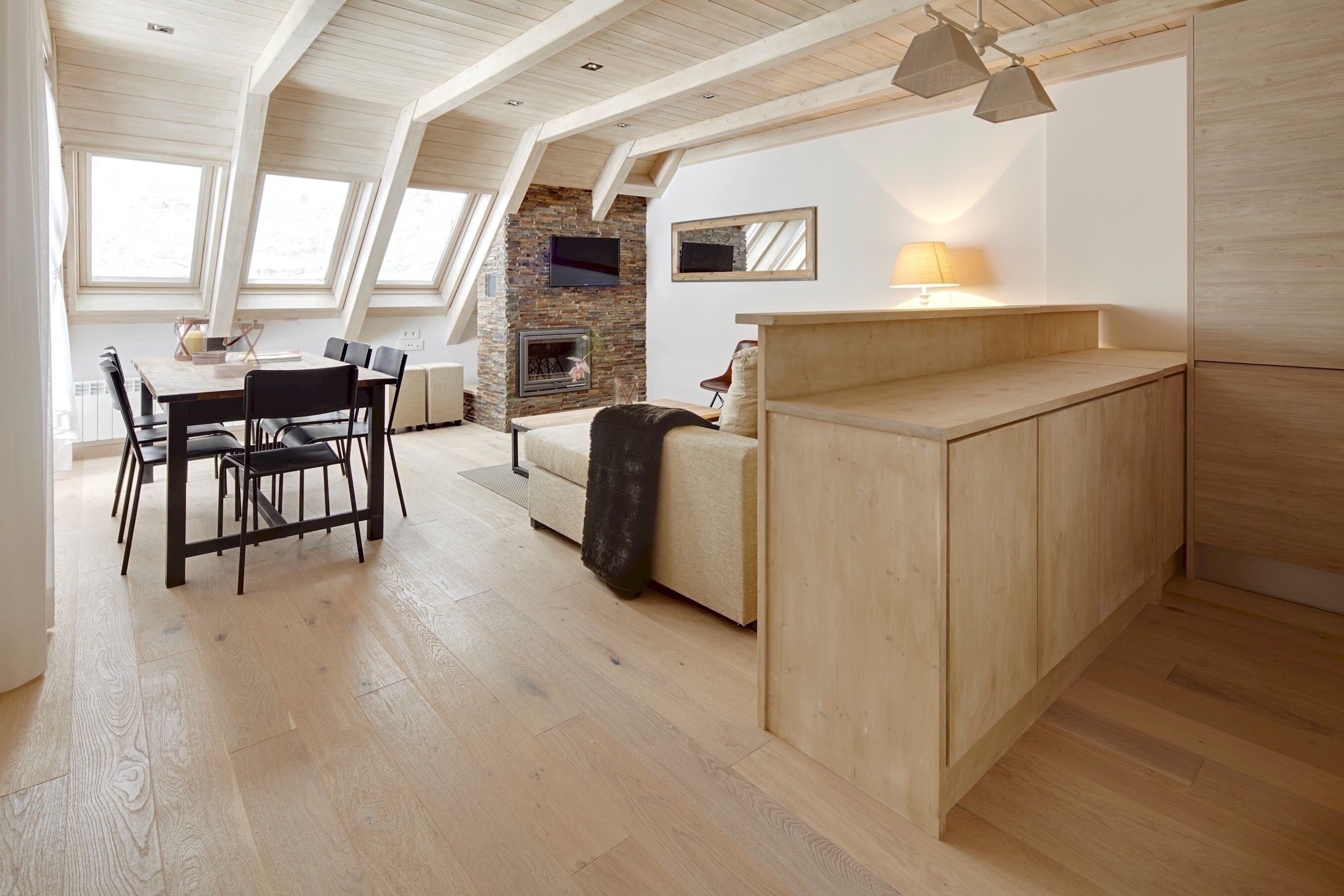 A modern loft-style living space with a dining area, a fireplace, and a cozy seating area.
