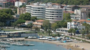 A coastal town with a marina, buildings, and a beach. - MEDES PARK I 2-7 (Estartit)