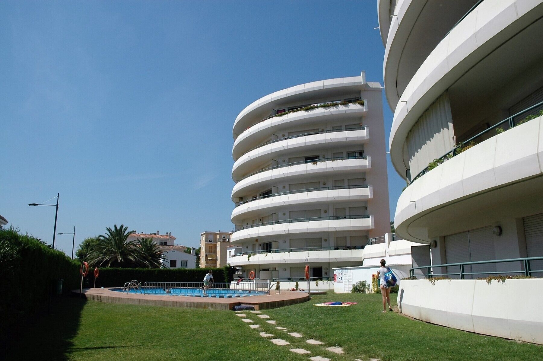 A modern multi-story building with a pool area.
