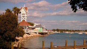 A coastal scene with a lighthouse, wooden docks, and boats. - Sunset Condo #156 on Anna Maria Island (Bradenton Beach)