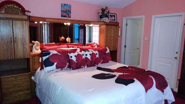 A bedroom with a bed, wooden wardrobe, and a door. - Mikey's Beach Place - 75 Yards To Our Beautiful Beaches & Dunes; Heated Pool! (Melbourne Beach)