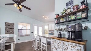 A modern kitchen with a bar area, white cabinetry, and a coffee machine. - Tucson Omni Oasis – 4BR-3BA Desert Retreat with Private Hot Tub & Fire Pit (Tucson)