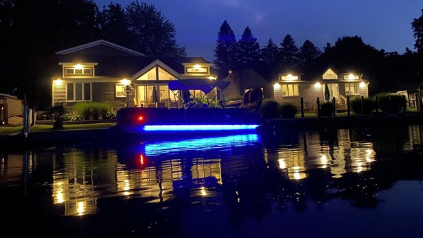 Una casa con un muelle que se adentra en una superficie acuática tranquila, que refleja la casa y el muelle.