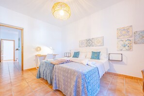 A bedroom with a bed, a bedside table, a lamp, and decorative wall art. - Villa Altamira - Plus (Calpe)