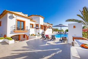 A modern villa with a swimming pool, outdoor seating, and a staircase leading to the upper floor. - Villa Altamira - Plus (Calpe)