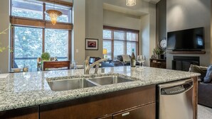 A kitchen with granite countertops, stainless steel appliances, and a built-in dishwasher. - Solstice 21 | Easy Walk to Eagle Lodge (mammoth lakes)