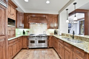 Enjoy cooking in this well-equipped kitchen with a granite countertop, double sink, and oven.